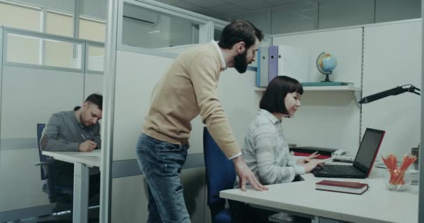 Krubban i kontoret kontrollera arbetet av hans anställda, gör en konversation med dem. 4k — Stockvideo