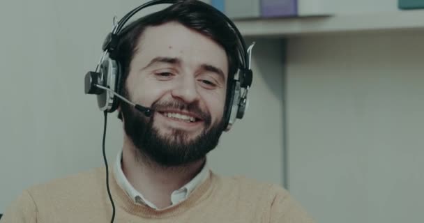 Εργαζόμενος υποστήριξη πελατών, μιλώντας με έναν πελάτη, κινηματογράφηση σε πρώτο πλάνο έχει ένα χαμογελαστό πρόσωπο — Αρχείο Βίντεο