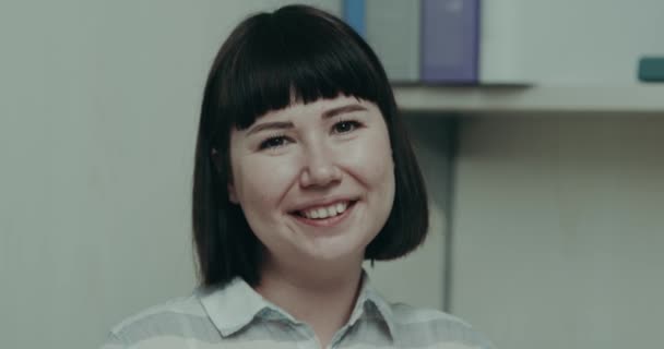 Jovem do sexo feminino brincando com emoção na frente da câmera em sua mesa de trabalho do escritório — Vídeo de Stock