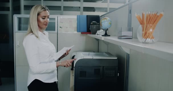 Mooie jonge zakenvrouw afdrukken in het kantoor — Stockvideo