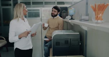 Genç genç bir erkekle kadın birkaç kağıt baskı almak büyük bir konuşma kadar ofiste var.