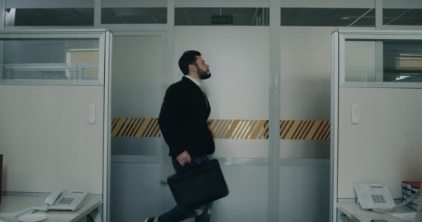 Joyeux employé de bureau dansant entrant dans le bureau, tous les collègues assis à leur bureau et souriant en regardant leur collègue. au ralenti — Video
