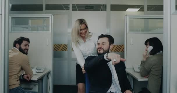 Офісні працівники розважаються на час перерви, красива блондинка бізнес-леді і її колега грають зі стільцем . — стокове відео