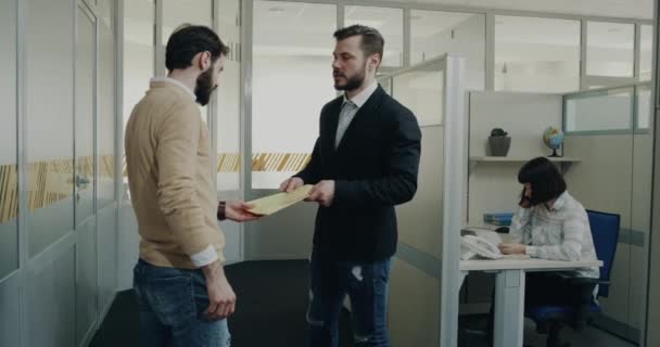 Två kollegor har en konversation i office hallen — Stockvideo