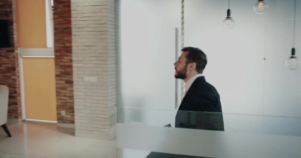 I de moderna business center unga män som kommer på jobbet leende med en glada ansikten som innehar en coupe av kaffe och en karta. — Stockvideo