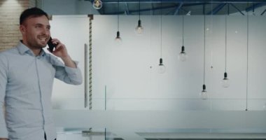 Karizmatik erkekler modern iş binanın içinde hareket eden telefon konuşma.