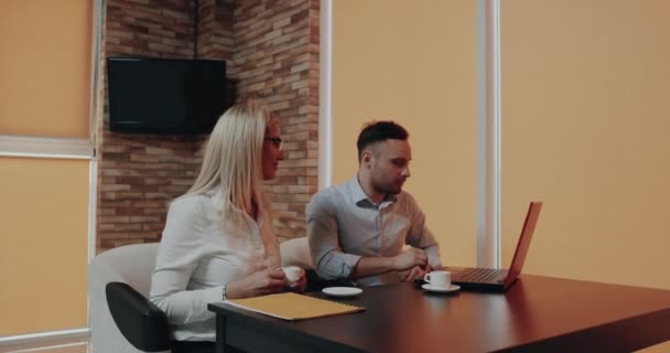 Geschäftspartner Frauen und Männer sprechen über die Arbeit und blicken mit zufriedenen Gesichtern auf den Laptop — Stockvideo