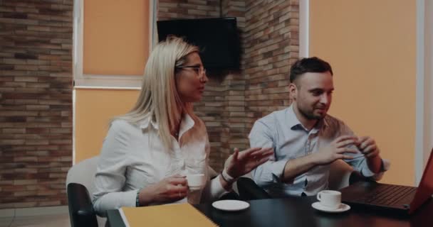 Primo piano giovani uomini e donne nel caffè hanno un incontro di lavoro guardando attraverso il computer portatile — Video Stock