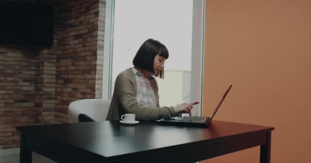 Mulher bonita em sua mesa de trabalho usou seu cartão de crédito e encomendar algo do laptop.4k — Vídeo de Stock