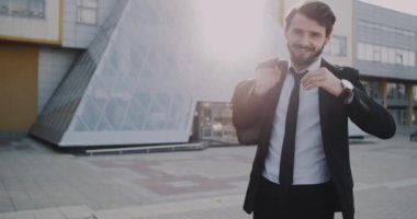 Modern ofis binası karizmatik kamera önünde gülümseyen bir takım elbise içinde bir iş adamı