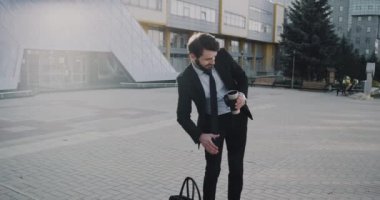Onun iş günü modern ofis binası önünde onun kahve içmeye başlamadan önce genç iş adamı.