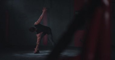 Koyu renk beden eğitimi sınıfında çok çekici bir genç adam sıkı çalışmadan önce aerobik egzersizle eğitimine başlıyor. 4k