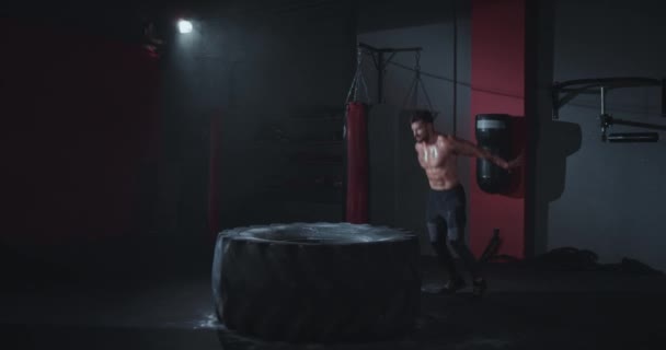 Przystojny przystojny dopasowanie ciało facet z a idealny mięśnie robi twarde ćwiczenia przeskakiwanie na a duży opona otrzymywać słodkie on trening w a cross fitness klasa — Wideo stockowe