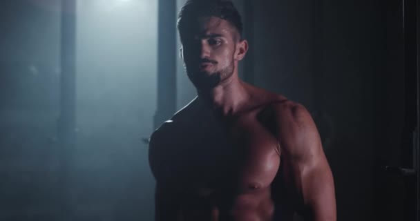 Attraktiver Bodybuilding-Typ, der in einem dunklen Cross-Fitness-Kurs direkt in die Kamera läuft — Stockvideo