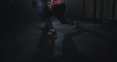 Güçlü vücutlu adam, karın kaslarında kas yapmak için top kullanarak sıkı bir antrenman yapıyor.