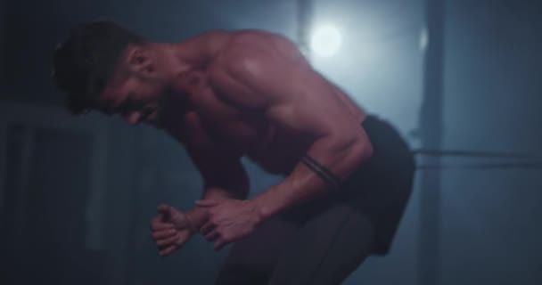 Attraktive Kerl mit starkem Körper in einem Cross-Fitness-Kurs haben ein hartes Training konzentriert er läuft, während ein elastisches Band hält seinen Bauch — Stockvideo