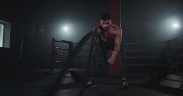 Тяжелое время тренировки для бодибилдинга человека с помощью веревок для выполнения тяжелых упражнений сконцентрированной работы хорошо — стоковое видео