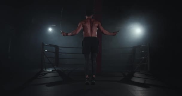 Bodybuilding άνθρωπος άλμα σκληρά για το σχοινί σε ένα σκοτεινό και σύγχρονο σταυρό τάξη φυσικής κατάστασης — Αρχείο Βίντεο