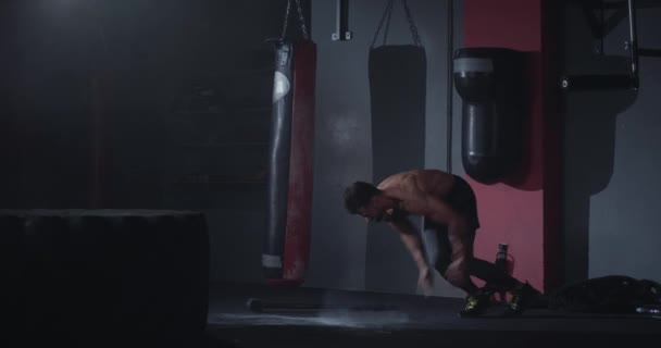 Treino duro para um jovem atlético com cheio de poder levantar o pneu, em seguida, fazer alguns push-ups rápido tomar o hummer e com todas as greves de energia sobre um pneu grande — Vídeo de Stock