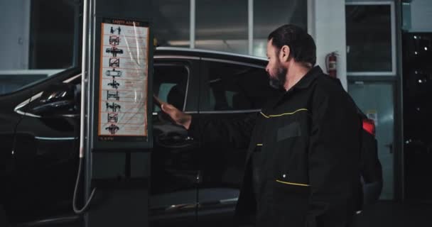 A modern autószerelő fő autószerelő ember kap az autó le, miután befejezte, hogy javítsa meg a sérült autó, autószerviz koncepció — Stock videók