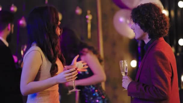 Perfektní noční večírek skvěle vypadající dáma a kudrnaté vlasy chlap těší noc, kdy jásot se sklenkou šampaňského a mají pěkný rozhovor — Stock video