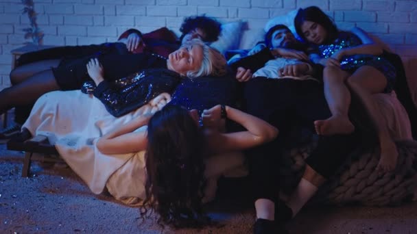 Twarda noworoczna grupa nastolatków dobrze się bawiła razem zasypiają wszyscy razem, ładna młoda dama próbuje obudzić swoich przyjaciół — Wideo stockowe