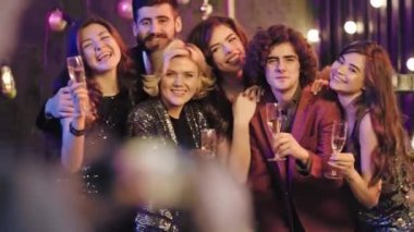 İş yerinden bir grup iyi görünümlü iş arkadaşı eğlenceli bir Noel partisi veriyor. Kameranın önünde ayağa kalktıkları için mutlular. Diğer meslektaşlar anılardan birkaç fotoğraf çekiyor.