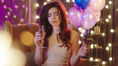 Noel partisinde koltukta oturan ve şampanya içerken anın tadını çıkaran kocaman gülüşlü çok güzel bir kadın.