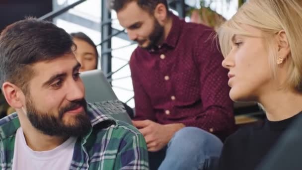 Primo piano ritratto di una signora bionda con i capelli corti e bel ragazzo hanno una conversazione amichevole nel loro studio ufficio moderno. Girato sulla macchina fotografica ARRI Cinema — Video Stock