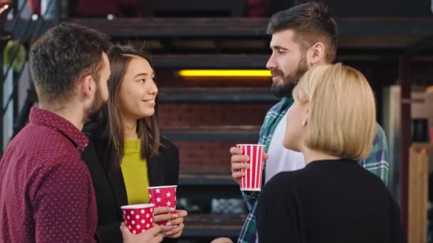 Gut aussehende junge Gruppe von Freunden multiethnisch, während sie eine Pause auf dem College trinken sie Kaffee und Geselligkeit lächelnd und entspannt fühlen — Stockvideo