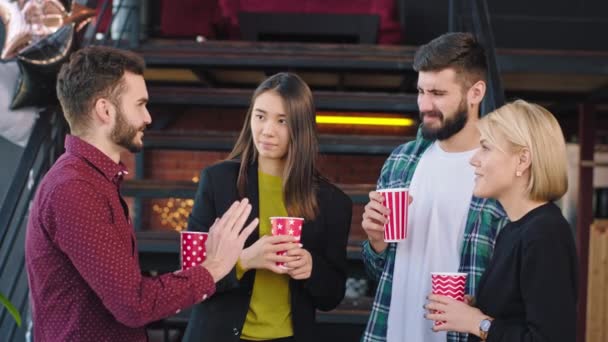 En el tiempo de descanso en una universidad multiétnica moderna socializar juntos sonriendo a lo grande y beber un poco de café delante de la cámara — Vídeos de Stock