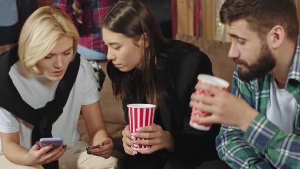 Proche de la caméra groupe de jeunes gens très jolie avoir une conversation amicale ils assis sur le canapé et boire quelques boissons — Video