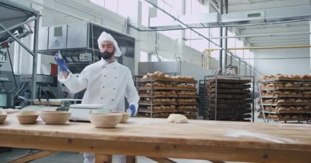 Boulanger excité avec la danse de la barbe et se déplaçant drôle à son lieu de travail dans la cuisine commerciale, il apprécie le temps tout en écoutant de la musique à partir d'écouteurs sans fil — Video