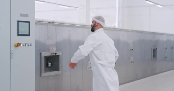 Dobře vypadající inženýr muž s mapou tanec s bezdrátovými sluchátky při chůzi dolů na výrobu potravinářského průmyslu se setkává s pracovníkem a dává pět — Stock video
