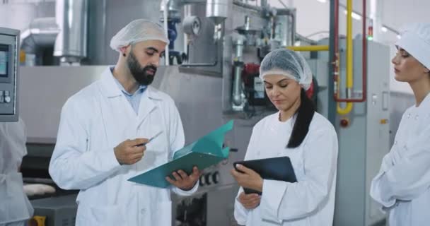 Ingénieur et son assistance ont un temps de réunion dans une industrie de boulangerie ils ont une conversation sur la machine industrielle — Video