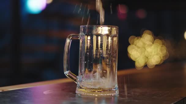 Movimento lento na frente da câmera derramando a cerveja em um copo com bolhas de closeup — Vídeo de Stock