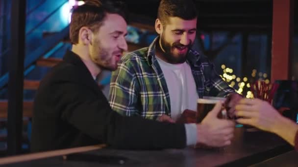 In a beer pub two charismatic guys a good friends drinking a food fresh beer from a big glasses they enjoying the time — Stock Video