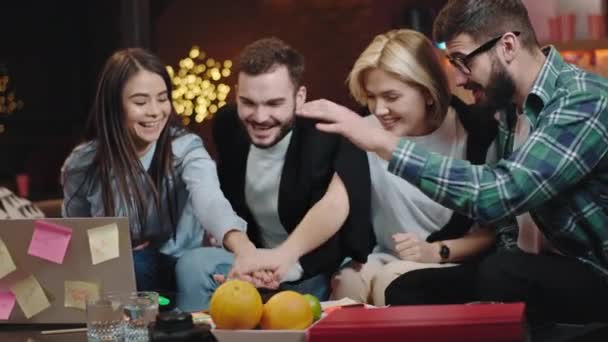 Aantrekkelijke en lachende grote groep kantoormedewerkers doen een plan van hun werk handen over hand en gelukkig begin te werken ze zijn een power team — Stockvideo