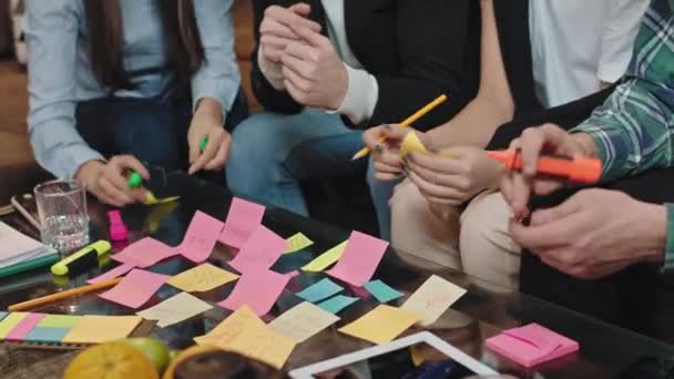 Nahaufnahme mit der Kamera in einem modernen Office Center Tisch große Büro-Team-Gruppe analysiert den statistischen Arbeitsplan machen einige Notizen auf dem kleinen Farbpapier — Stockvideo