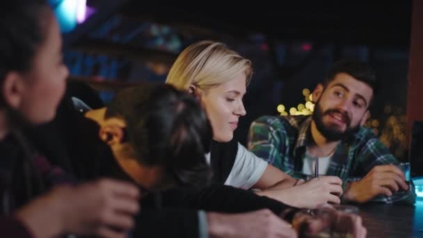 Grupo de mujeres jóvenes y hombres disfrutando de la noche en el bar pasan un buen rato bebiendo algunos cócteles y sintiéndose relajados — Vídeo de stock