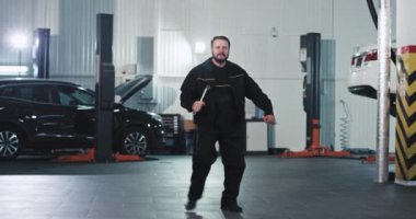 Tamirci işini bitirdikten sonra araba servisinin ortasında dans ederken harika zaman geçirmiş.