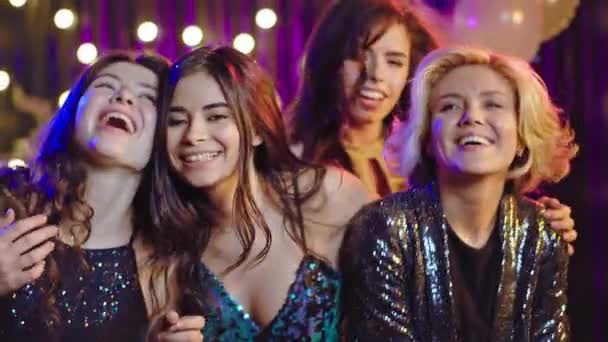 Glimlachende mooie dames poseren voor de camera op spullen feestje ze voelen zich opgewonden kijken recht naar de camera — Stockvideo
