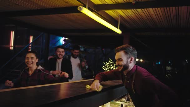 Bon attrayant barman faire des cocktails pour le groupe de jeune sorcière client est venu à la tablette du bar très excité qu'ils attendent les boissons — Video