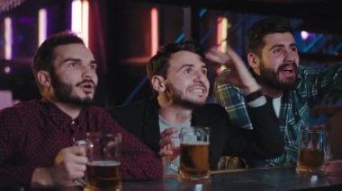 Çekici bir grup erkeğin bir televizyon maçı izlemek için bir araya geldiği bir bar. Maça odaklanmışlar ve gerginler.
