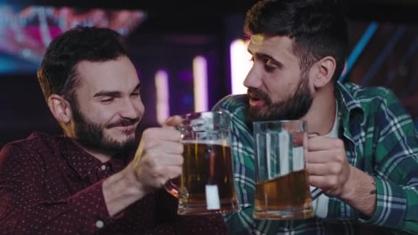 Chicos carismáticos con barbilla pasando un buen rato en un pub bebiendo cerveza charlando y sonriendo a lo grande disfrutando de la noche. Grabado en la cámara de cine ARRI — Vídeos de Stock