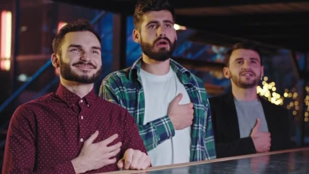 Three charismatic guys concentrated and emotional watching the end of the game — ストック動画