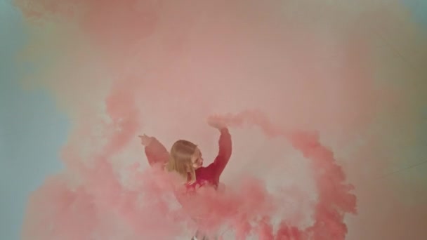 Добре виглядає леді танцівниця добре провести час всередині студії, взявши відео зверху вона тримає кольорову димову бомбу і отримує задоволення — стокове відео