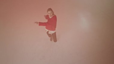 Büyük bir stüdyoda, dans eden bayanın videosunu çekiyor. Çok karizmatik, pembe tozlar taşıyor.