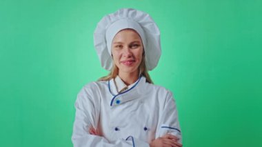 Yeşil bir stüdyo krom anahtarının içinde kameranın önünde poz veren yakışıklı genç fırıncı güzel gülümsüyor ve el ele tutuşuyor.