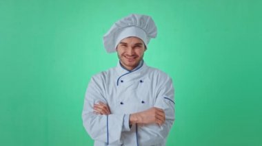 Yeşil arka plan karizmatik fırıncı, fırıncı üniformalı adam kameranın önünde poz veriyor. Büyük bir benzerlik gösteriyor ve gülümsüyor. Arri Alexa Mini 'ye ateş edildi.